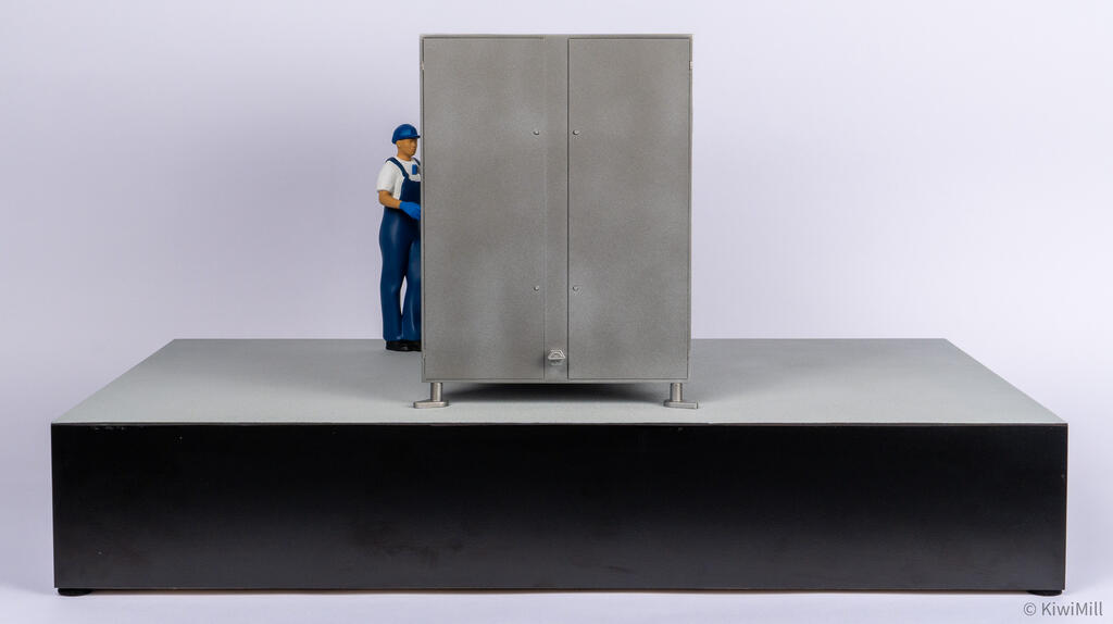Straight-on end view of the chiller model's double access doors on leveling feet, with the operator figure behind